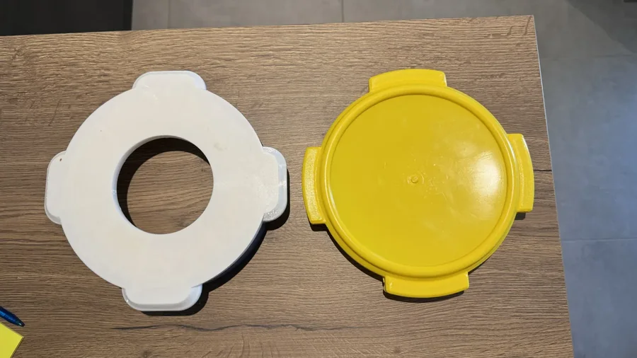 Couvercle adapté imprimé en 3D (en blanc), à côté du couvercle d’origine du bidon