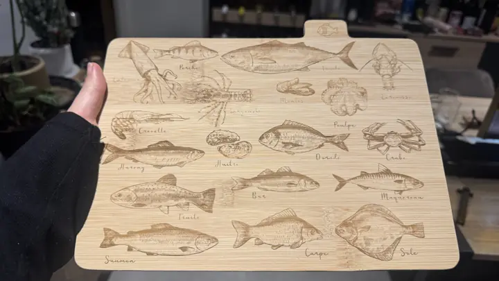 Planche à découper gravée d’une illustration de poissons