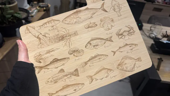 Planche à découper gravée d’une illustration de poissons